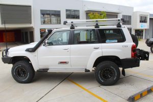 Left side view of a white GU Nissan Patrol Wagon after being fitted with a full 2 Inch Superflex Lift Kit featuring Airbag Man airbags