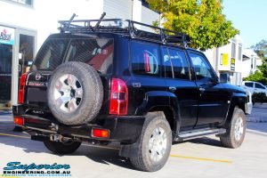 Rear right view of a Black Nissan GU Patrol Wagon being fitted with a Superior 2" Inch Nitro Gas Lift Kit, Airbag Man 2" Inch Coil Air Helper Kit, Safari Snorkel, Brown Davis Long Range Fuel Tank, Superior Coil Tower Brace Kit & Superior Upper Control Arms