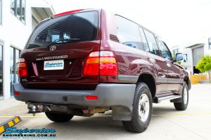 Rear right view of a Maroon Toyota 105 Series Landcruiser Dual Cab before fitment of a Superior Nitro Gas 3" Inch Lift Kit with Airbag Man 3" Coil Air Kit