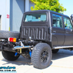 Rear right view of a Black Toyota 79 Series Landcruiser Dual Cab after fitting a Superior Remote Reservoir 2" Inch Lift Kit with Airbag Man Leaf Air Kit