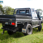 Rear right side view whilst flexing of a Grey Toyota 79 Series Landcruiser Dual Cab after fitment of a Superior 4" Inch Rear Coil Conversion Kit.