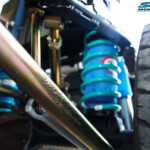 Left mid rear up close view of the fitted Superior Lower Control Arm, Coil Spring with Airbag Man Coil Air Kit and Sway Bar Kit