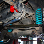 Front underbody view of the fitted Superior Heavy Duty Tow Points, Drag Link Bar, Coil Springs + Steering Damper