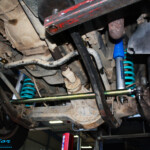 Mid underbody view looking front on of the fitted Superior Tie Rod Bar, Nitro Gas Shocks + Coil Springs