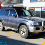 Right front side view of a Grey Toyota 100 Series Landcruiser before fitment of a 2" Inch Lift Kit with Airbags