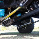 Mid rear left outside view of the fitted Superior Lower Control Arm, Sway Bar Kit & Airbag Man Coil Air Helper Kit with Coil Spring