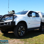 Left front side view of a White Holden RG Colorado Dual Cab after fitment of a Superior Remote Reservoir 2" Inch Lift Kit, Superior Chassis Brace/Repair Plate, Airbag Man Leaf Air Kit & Clearview Towing Mirrors
