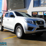 Right front side view of a Silver Nissan NP300 Navara Dual Cab before fitment of a Superior Remote Reservoir 2 Inch Lift Kit & Airbag Man Coil Air Kit 2" Inch Lift