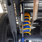 Rear left underbody view of the fitted Adjustable Monotube Piggyback Remote Reservoir Shock, Coil Spring & Airbag Man Coil Air Kit