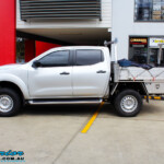 Left side view of a Silver Nissan NP300 Navara Dual Cab after fitment of a Superior Remote Reservoir 2 Inch Lift Kit & Airbag Man Coil Air Kit 2" Inch Lift
