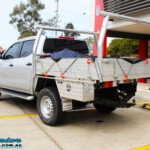 Rear left view of a Silver Nissan NP300 Navara Dual Cab after fitment of a Superior Remote Reservoir 2 Inch Lift Kit & Airbag Man Coil Air Kit 2" Inch Lift