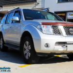Right front side view of a Nissan R51 Pathfinder in Silver after fitment of a Airbag Man Standard Height Coil Air Kit