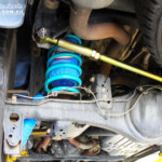 Rear left underbody shot showing the fitted Superior Remote Reservoir Shock Absorber, Coil Spring, Superior Rear Panhard Rod & Airbag Man Coil Air Helper Kit
