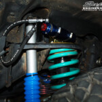 Inner left side guard view of the fitted Superior 3" Remote Reservoir shock with Coil Spring